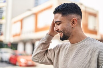 Wall Mural - Young arab man smiling confident standing at street