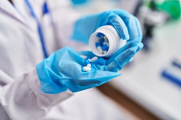 Sticker - Young caucasian woman scientist holding pills at laboratory