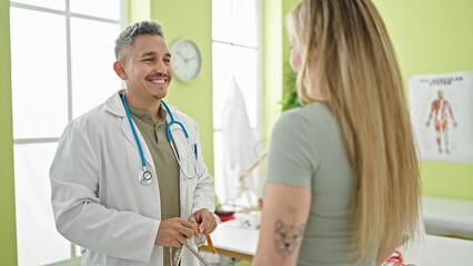 Canvas Print - Man and woman dietician and patient speaking at the clinic