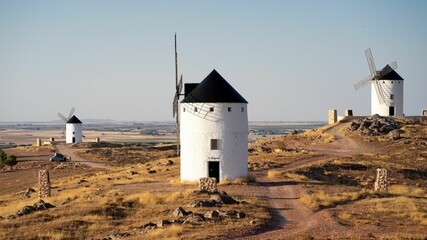 Sticker - three windmills stand on top of a hill with a path