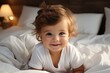 A charming smiling baby in a white sunny bedroom. A baby crawling in bed. Nursery for small children. Textiles and bed linen for children. Family morning at home.