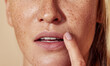 © Artem Varnitsin - Close-up of unrecognizable woman with freckled skin touching lips with finger