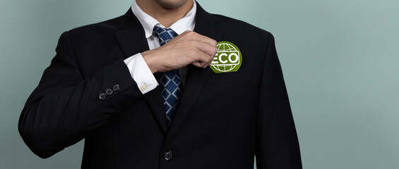 Eco-friendly corporate promoting sustainable and green business concept with businessman hold ECO symbol paper as environmental protection commitment using clean energy with zero CO2 emission. Alter