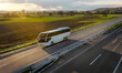 White Modern comfortable tourist bus driving through highway at bright sunny sunset. Travel and tourism concept. Trip and journey by road vehicle