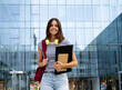 © gonzagon - Portrait of student girl with folder in a campus looking at camera smiling. Happy student