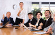 © JackF - Office coworkers of different ages watching presentation while sitting at table with laptop and notes