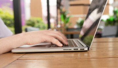 Close-up of a hands of a young man typing on his laptop. 