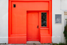 A Red Door Background.Retro Style Of Red Door And Old Plastered Grey Facade Wall.Summer Day.