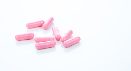 Wall Mural - Pink capsule pills on white background. Pharmaceutical industry. Vitamins, minerals, and supplements concept. Pharmacy products. Pharmaceutical medicine. Prescription drugs. Healthcare and medicine.