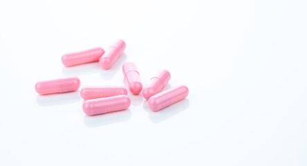 Sticker - Pink capsule pills on white background. Pharmaceutical industry. Vitamins, minerals, and supplements concept. Pharmacy products. Pharmaceutical medicine. Prescription drugs. Healthcare and medicine.