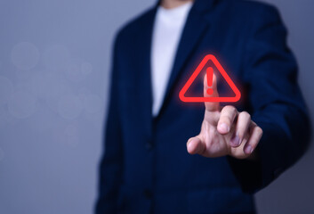 Wall Mural - businessman using laptop showing warning triangle and exclamation sign icon warning of dangerous pro
