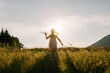 Silhouette of preteen girl kid run with airplane on background majestic mountains during warm summer sunset. Dream freedom concept. Playful child runs on green meadow holding in hands toy aircraft