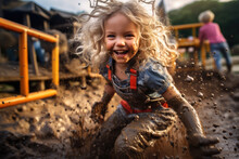 Happy Childhood Picture Of A Little Girl Laughing, Having Fun Playing In Mud Of A Playground After Rain With Copy Space