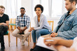 © dikushin - Stressed black young woman complaining about alcohol addiction with people and therapist at meeting. Upset female talking about depression and anxiety with patients in circle. Concept of mental health
