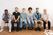 © dikushin - Portrait of tired multicultural and different ages professional business people for vacancy sitting on chairs in row looking at camera, on white isolated background. Human resource concept