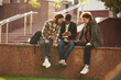 Three young students in casual clothes are together outdoors