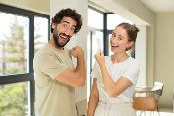 Canvas Print - young adult couple feeling happy, positive and successful, motivated when facing a challenge or celebrating good results