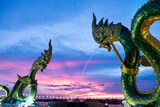 Fototapeta  - Big green naga statue in riverside on mekong river is landmark in nongkhai city Thailand with twilight background.