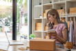 © Natee Meepian - Startup small business entrepreneur SME, asian woman check order. Portrait young Asian small business owner home office, online sell marketing delivery, SME ecommerce concept