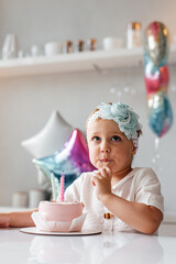 Adorable three year old kid celebrating his birthday and blowing candles on homemade baked cake, indoor.