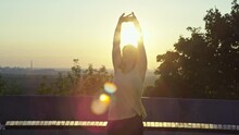 A Beautiful Girl Does Morning Exercises At Dawn In The City. A Woman Does Exercises And Stretches In The Park. High Quality 4k Footage