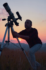 Wall Mural - astronomer looking at the skies with a telescope.