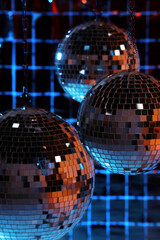 Poster - Shiny disco balls against foil party curtain under color lights