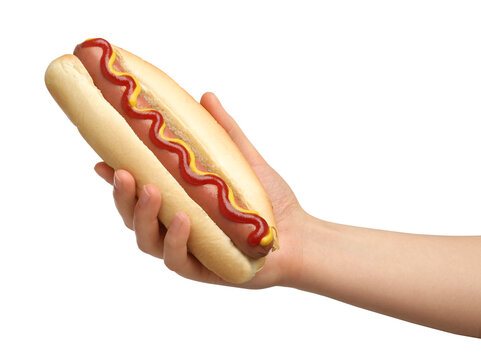 Woman holding delicious hot dog with mustard and ketchup on white background, closeup