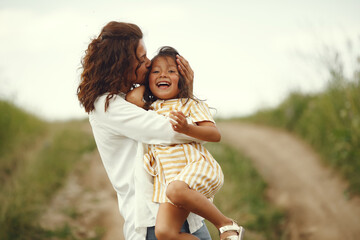 Mother with daughter playing in a summer field