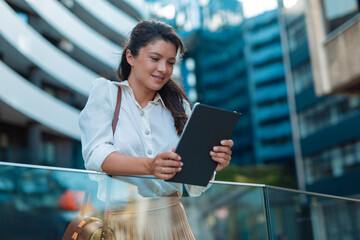 Wall Mural - Portrait of young business woman using tablet outdoor