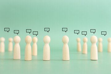 Wooden figures with speech bubbles. Concept of communication, information, and cooperation