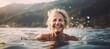 © id512 - a mature, happy woman joyfully swims in the crystal-clear lake on a warm summer day, with the sun glistening on the water's surface