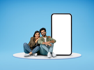 Wall Mural - Cute hindu millennial couple sitting by huge phone, mockup