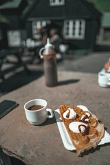 Sticker - Stock photo features a close-up of delicious-looking waffles and a steaming cup of coffee