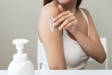 Body Skin Care Routine Concept. Close-up View Hands Of A Young Woman Applying Lotion Cream On The Shoulder
