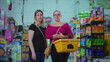 © Marco - Portrait of two serious female customers standing inside grocery store holding basket in hand. Middle-aged women posing for camera at supermarket with worried stern expression