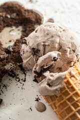 Wall Mural - Delicious scoop of chocolate ice cream on a cone near a sprinkling of chocolate shavings