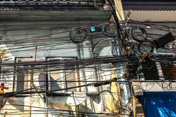 Sticker - photograph of an electric pole with lots of cables on it on the street of Bangkok.