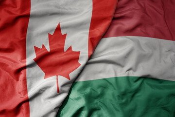 Wall Mural - big waving realistic national colorful flag of canada and national flag of hungary .