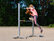 Girl jumping on hobby horse. Champion. Horse sport. Summer light. Green outdoor trees background. Child sport. Banner