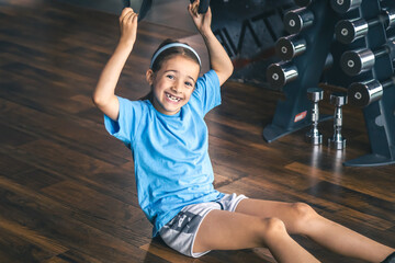 Little girl using trx fitness straps for working with his own weight.