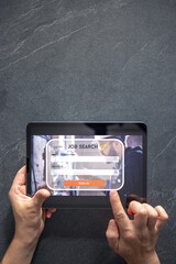 Wall Mural - top view of digital tablet with search job on screen in male hands.