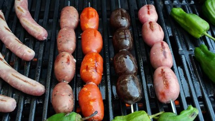 Wall Mural - Cooking sausages on barbeque grill. Different types. A sausage is getting turned on a grill. Close-up.