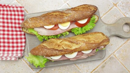 Wall Mural - gros plan sur deux sandwichs jambon et crudités sur une planche à découper