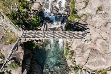 Wall Mural - vertical aerial view of the wooden bridge over cornisello lake in trentino