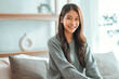 © oatawa - Confident smiling young adult asian woman looking at camera while sitting at home, Happy beautiful lady pretty face dental smile posing alone indoors.