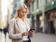 © Islam - Close-up image of business woman watching smart mobile phone device outdoors. Businesswoman networking typing an sms message in city street.