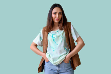 Wall Mural - Stylish young woman in tie-dye t-shirt and waistcoat on light blue background