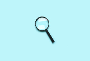 Wall Mural - Black mini magnifier on blue background