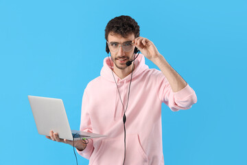 Poster - Male technical support agent with laptop on blue background